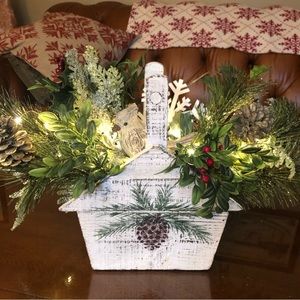 Handmade wooden basket with bird and holiday greenery with Lights.